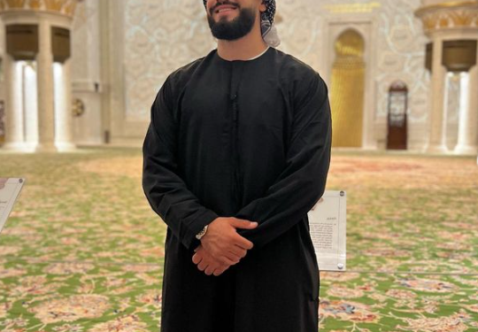 Capital T pozon nga xhamia Sheikh Zayed Grand Mosque në Dubai