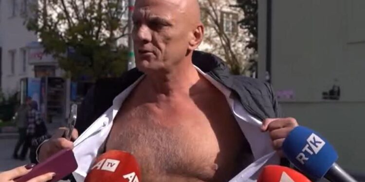 “A pe shihni këtë gjyks”: Gani Geci e zhvesh këmishën dhe iu kërkon ballafaqim atyre që shkruan grafitet