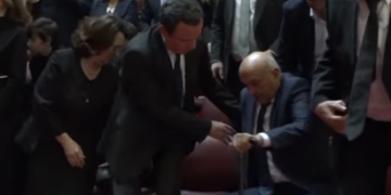 Kurti ndihmon Isa Mustafën të ngritet në këmbë gjatë intonimit të himnit në mbledhjen përkujtimore për Bujar Bukoshin